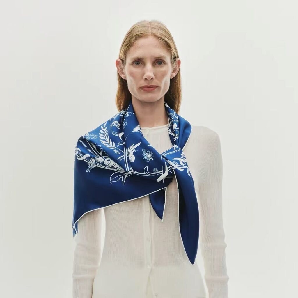 10 Chic Ways to Tie a Silk Scarf 1 A stylish woman looking confident, wearing a 90cm patterned mulberry silk scarf tied effortlessly around her neck.